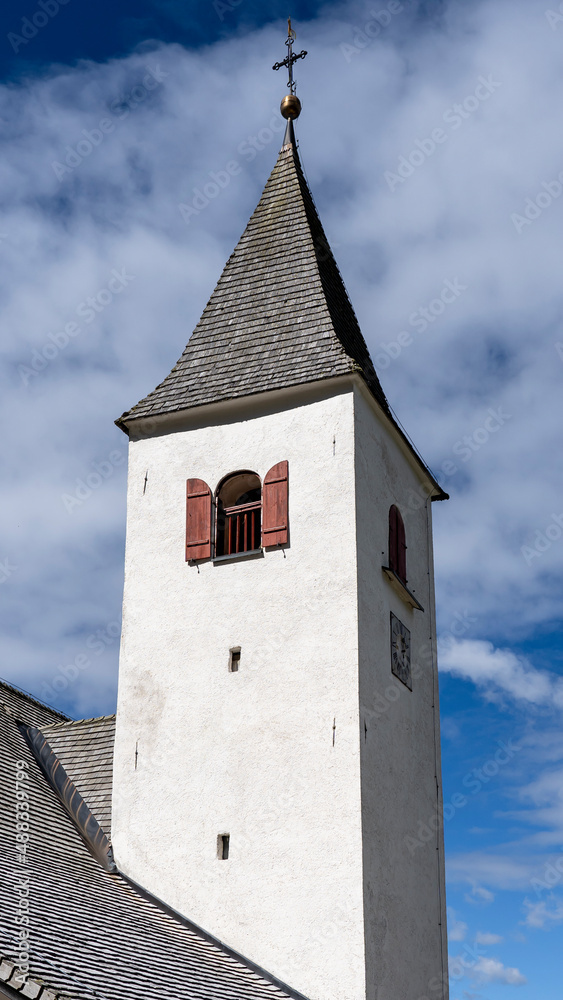 La Crusc. The bell tower of the church. Typical Tyrolean church tower. General context. Badia, Alto Adige, South Tyrol, Italy La Crusc. The bell tower of the church. Typical Tyrolean church tower. General context. Badia, Alto Adige, South Tyrol, Italy