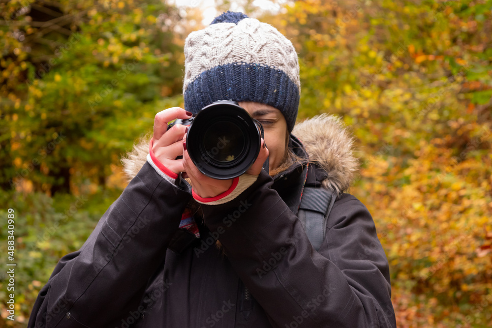 Young woman taking a photograph in an autumn landscape Young woman taking a photograph in an autumn landscape