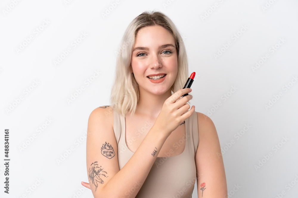 Young caucasian woman isolated on white background holding red lipstick Young caucasian woman isolated on white background holding red lipstick