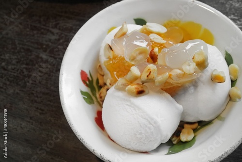 Thai style coconut ice cream topping with roasted peanuts, sweet pineapple and sweet palm kernels, serving on vintage enamelware
