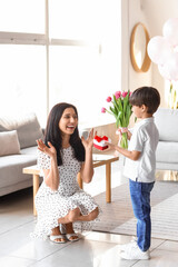Little son greeting his mother for International Women's day at home