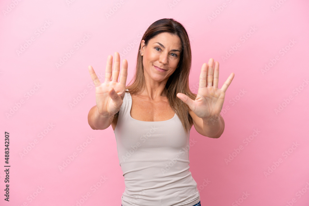 Middle age caucasian woman isolated on pink background counting nine with fingers Middle age caucasian woman isolated on pink background counting nine with fingers