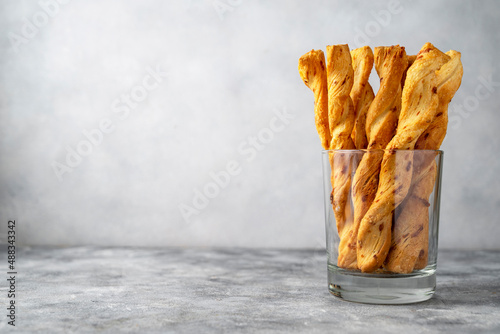 Cheese breadsticks with cheese in glass, snack food. Copy space.