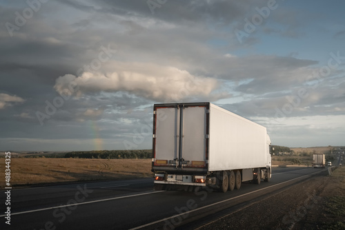 Freight truck under dramatic stormy sky with rainbow © tarasov_vl