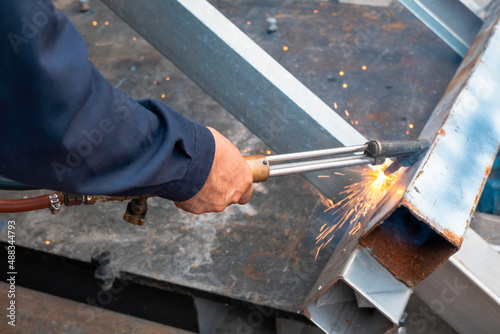 Construction workers working without protective equipment can be dangerous. Workers cutting steel with sparks do not wear protective gloves.