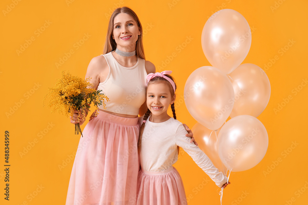 Little girl, her mother with flowers and balloons on yellow background Little girl, her mother with flowers and balloons on yellow background