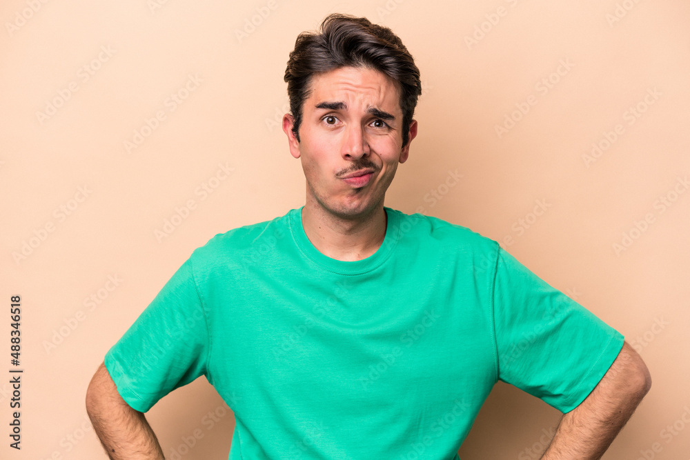Young caucasian man isolated on beige background confused, feels doubtful and unsure. Young caucasian man isolated on beige background confused, feels doubtful and unsure.