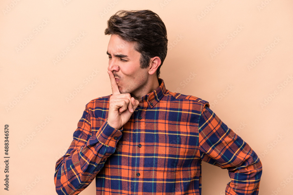 Young caucasian man isolated on beige background keeping a secret or asking for silence. Young caucasian man isolated on beige background keeping a secret or asking for silence.