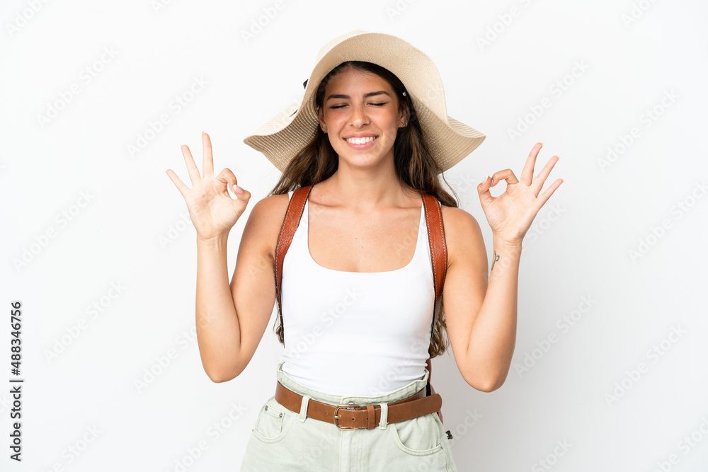Young caucasian woman wearing a Pamela in summer holidays isolated on white background in zen pose Young caucasian woman wearing a Pamela in summer holidays isolated on white background in zen pose
