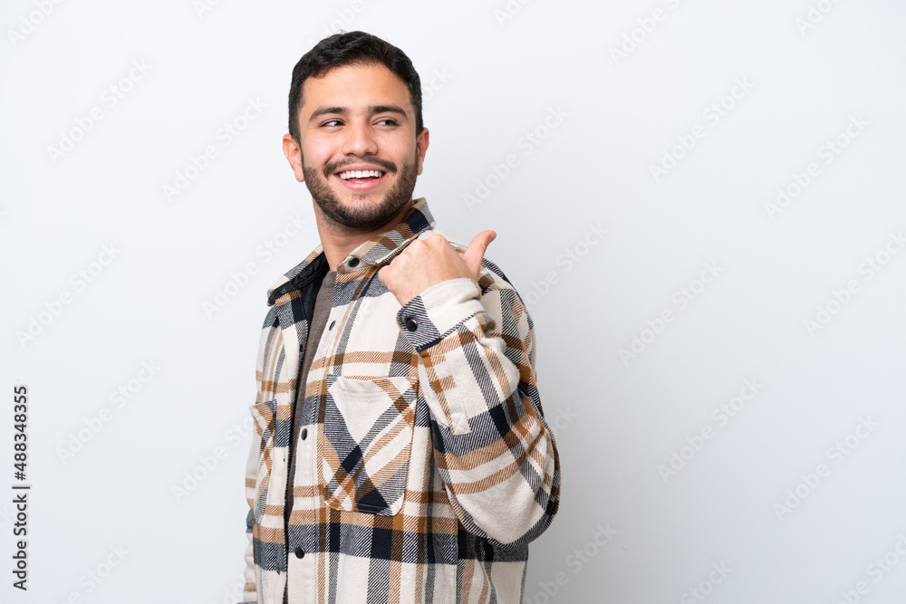 Young Brazilian man isolated on white background pointing to the side to present a product Young Brazilian man isolated on white background pointing to the side to present a product