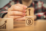 Concept of bitcoin growth, arrow up. BTC graph of the growth symbols on a wooden cubes in hands close-up view