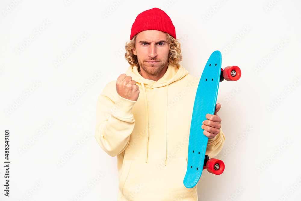 Young skater caucasian man isolated on white background showing fist to camera, aggressive facial expression. Young skater caucasian man isolated on white background showing fist to camera, aggressive facial expression.