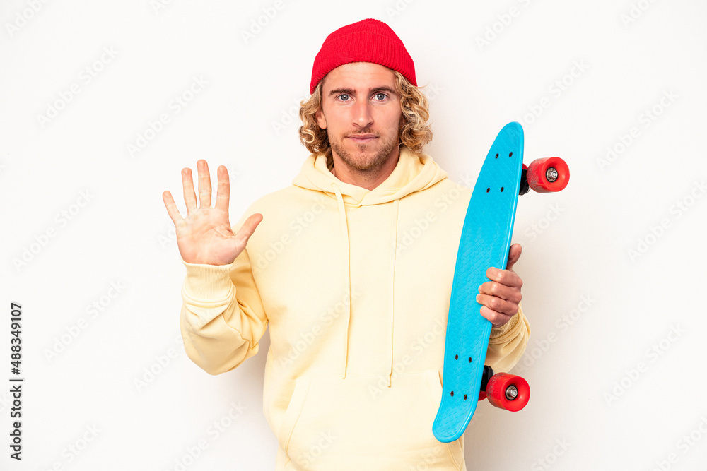 Young skater caucasian man isolated on white background smiling cheerful showing number five with fingers. Young skater caucasian man isolated on white background smiling cheerful showing number five with fingers.