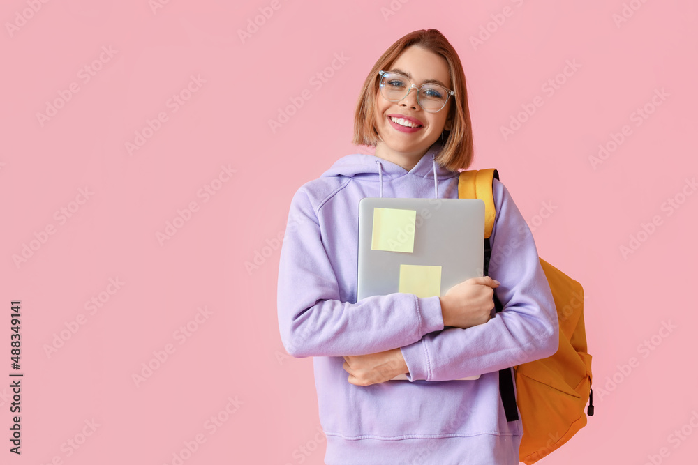 Female student with laptop on pink background Female student with laptop on pink background