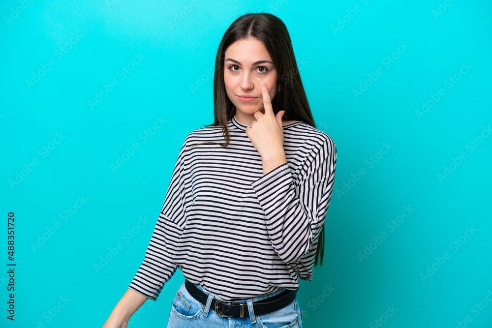 Young caucasian woman isolated on blue background showing something Young caucasian woman isolated on blue background showing something