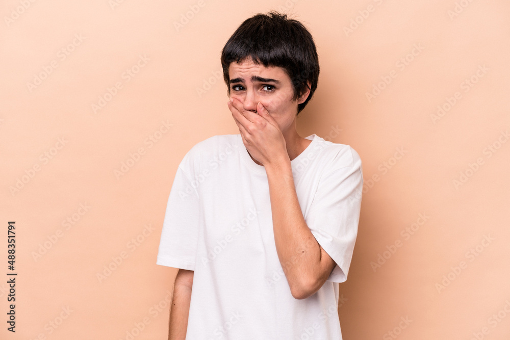 Young caucasian woman isolated on beige background scared and afraid.