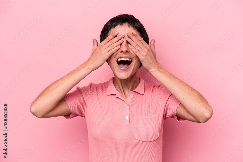 Young caucasian woman isolated on pink background covers eyes with hands, smiles broadly waiting for a surprise. Young caucasian woman isolated on pink background covers eyes with hands, smiles broadly waiting for a surprise.