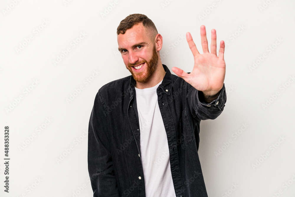 Young caucasian man isolated on white background smiling cheerful showing number five with fingers. Young caucasian man isolated on white background smiling cheerful showing number five with fingers.
