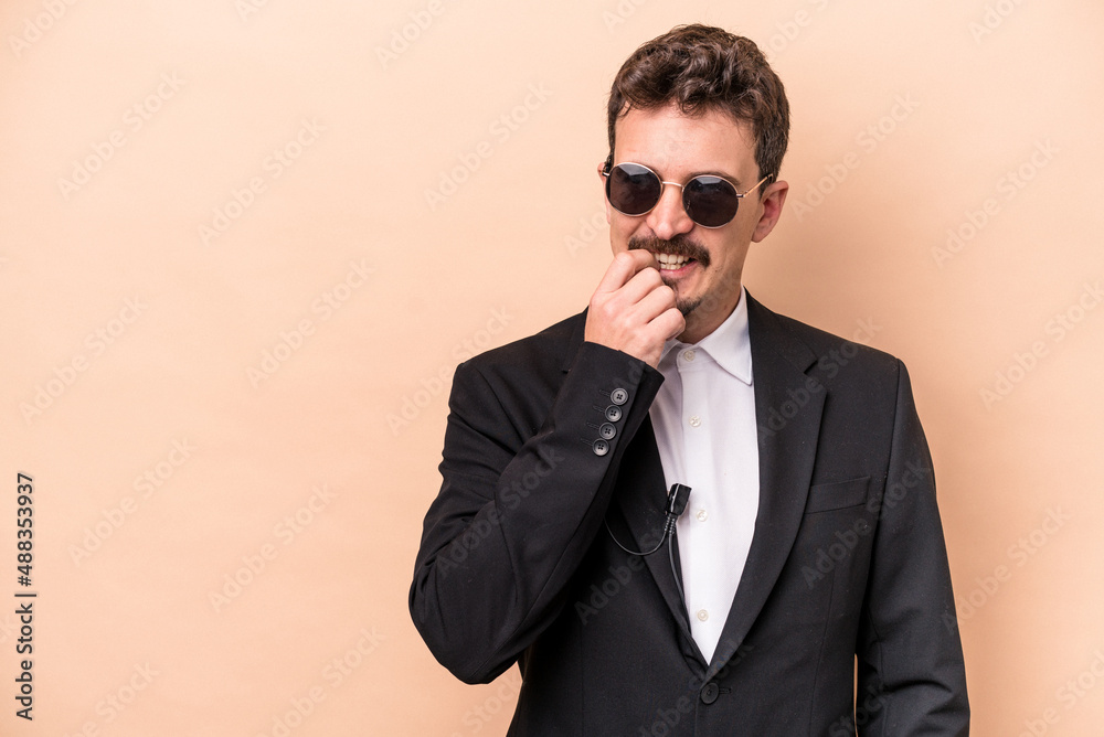Young bodyguard caucasian man isolated on beige background relaxed thinking about something looking at a copy space. Young bodyguard caucasian man isolated on beige background relaxed thinking about something looking at a copy space.