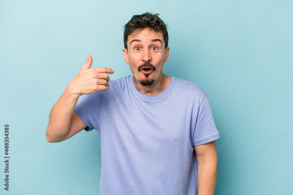 Young caucasian man isolated on blue background laughing about something, covering mouth with hands. Young caucasian man isolated on blue background laughing about something, covering mouth with hands.