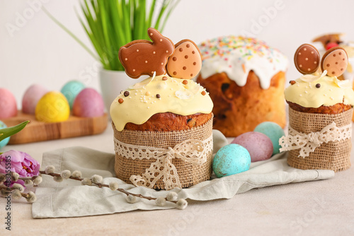 Tasty Easter cakes decorated with cookies on table