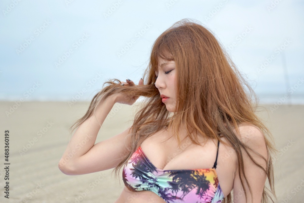 ビーチでポーズをとるビキニの水着を着た若い女性
