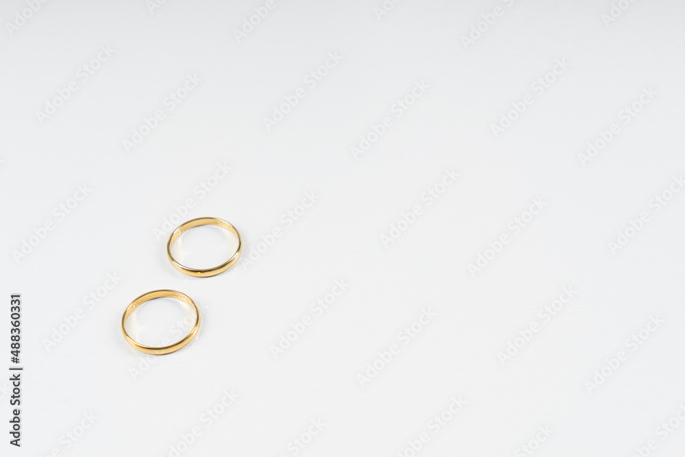 Gold wedding rings on a white background with copy space