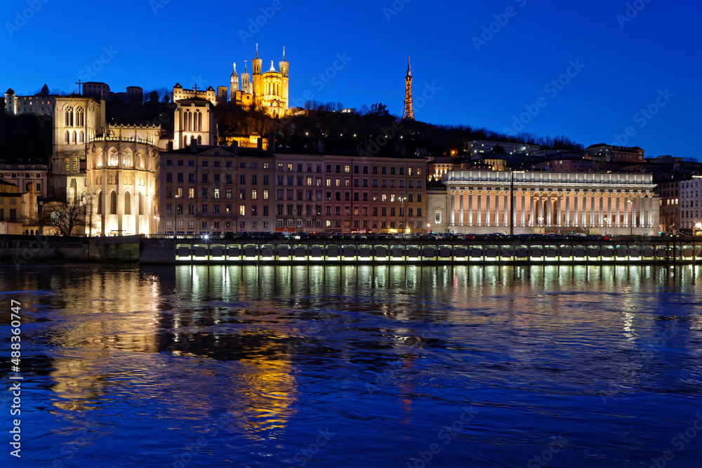 LYON, FRANCE, February 19, 2022 : St-Jean Cathedral, Fourviere basilica and Court house reflect in the waters of Saone river at the blue hour.