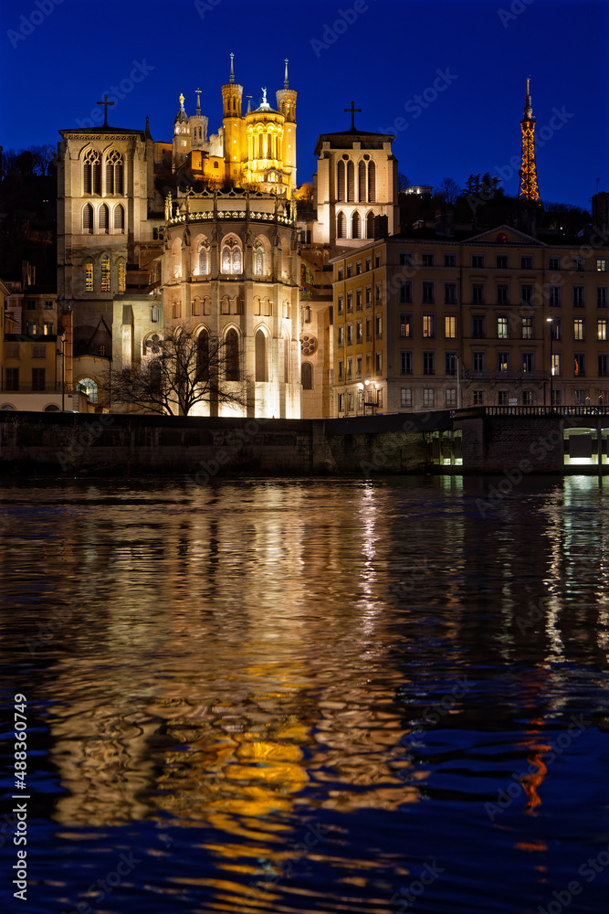 LYON, FRANCE, February 19, 2022 : St-Jean Cathedral and Fourviere basilica reflect in the waters of Saone river at the blue hour.
