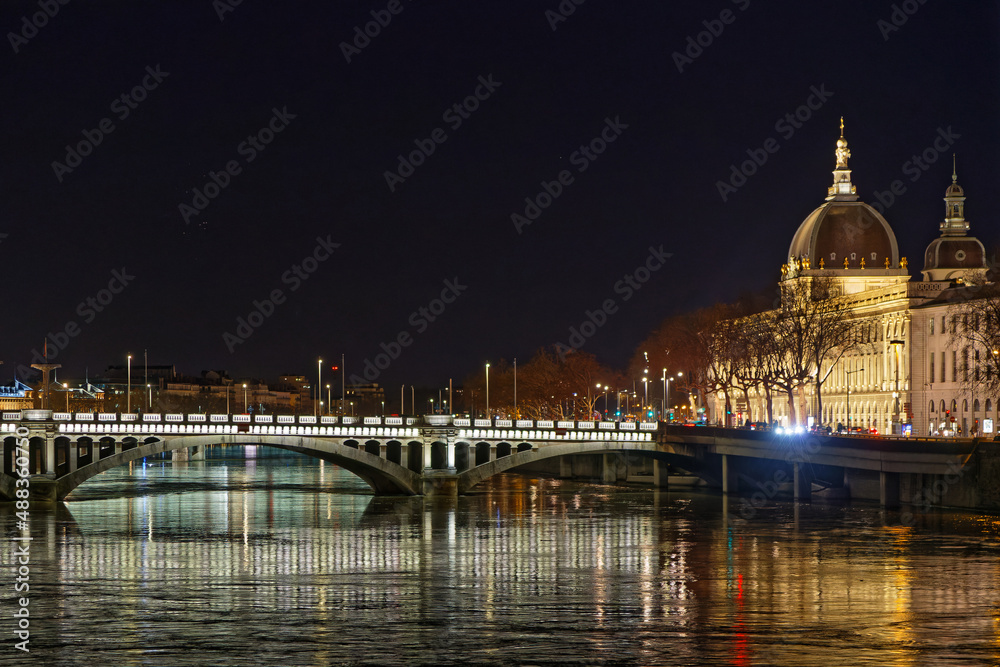LYON, FRANCE, February 19, 2022 : Rhone river and lighten Hotel Dieu buildings at night