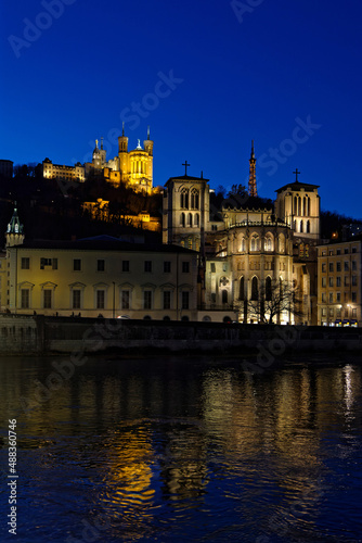 LYON, FRANCE, February 19, 2022 : St-Jean Cathedral and Fourviere basilica reflect in the waters of Saone river at the blue hour.