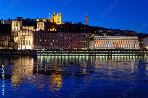 LYON, FRANCE, February 19, 2022 : St-Jean Cathedral, Fourviere basilica and Court house reflect in the waters of Saone river at the blue hour.