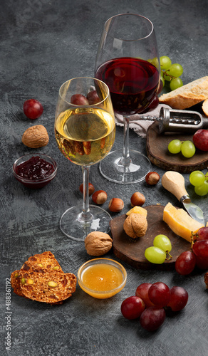 Red wine with appetizers on gray background.