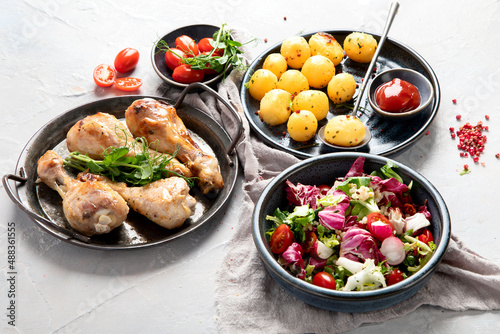 Baked chicken legs with salad and potatoes