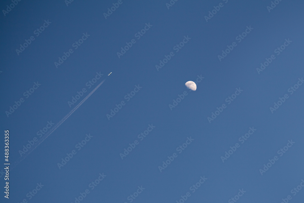 Plane flies against the background of the moon Plane flies against the background of the moon