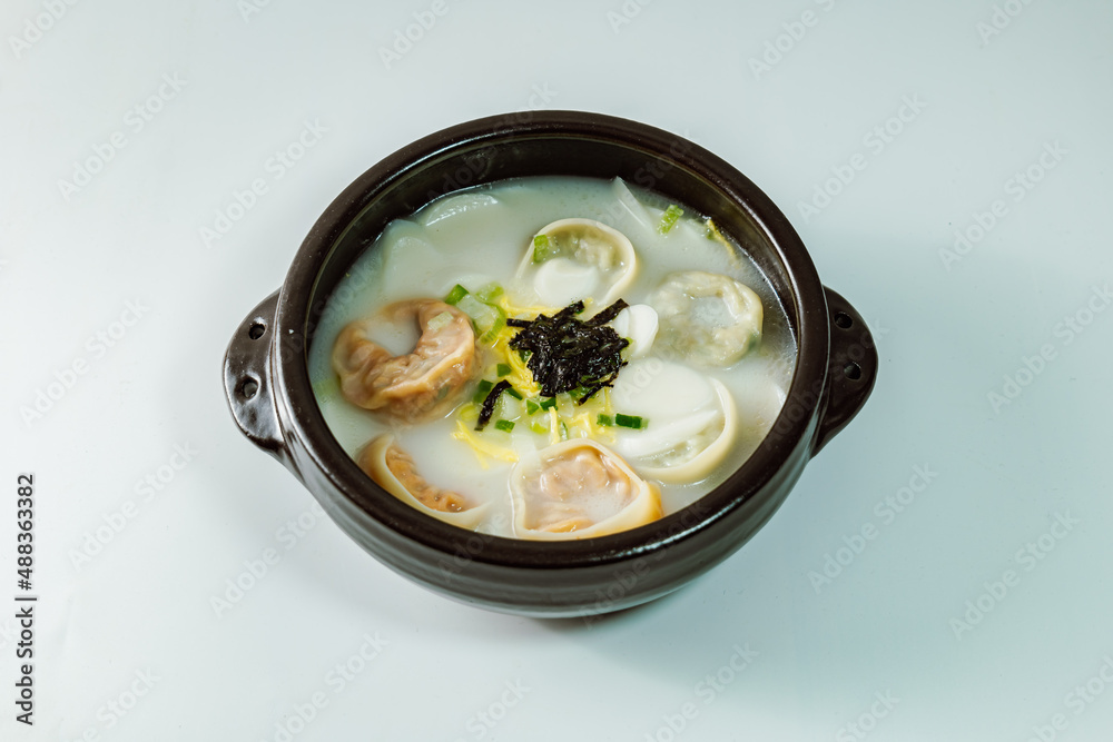 tteok mandu guk, Korean style dumpling soup with sliced rice cake tteok mandu guk, Korean style dumpling soup with sliced rice cake