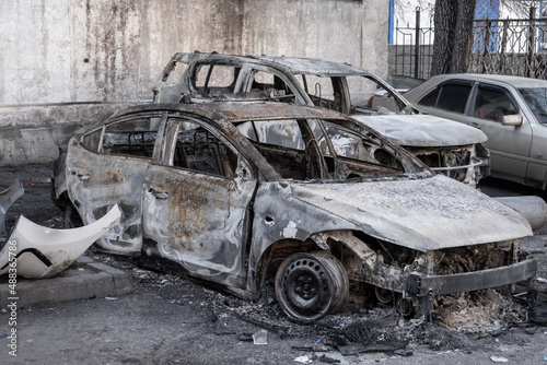 Closeup of burnt-out car completely destroyed due to arson during demonstrations. Vandalism concept.