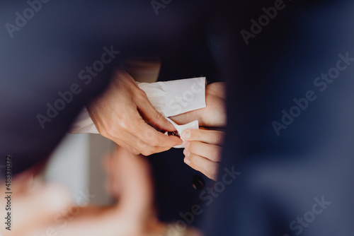 Le témoin aidant le marié à mettre ses boutons de manchettes photo