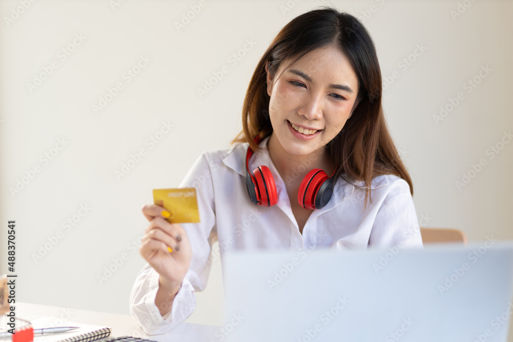 Woman holding credit card using laptop at home. Online shopping concept. Woman holding credit card using laptop at home. Online shopping concept.