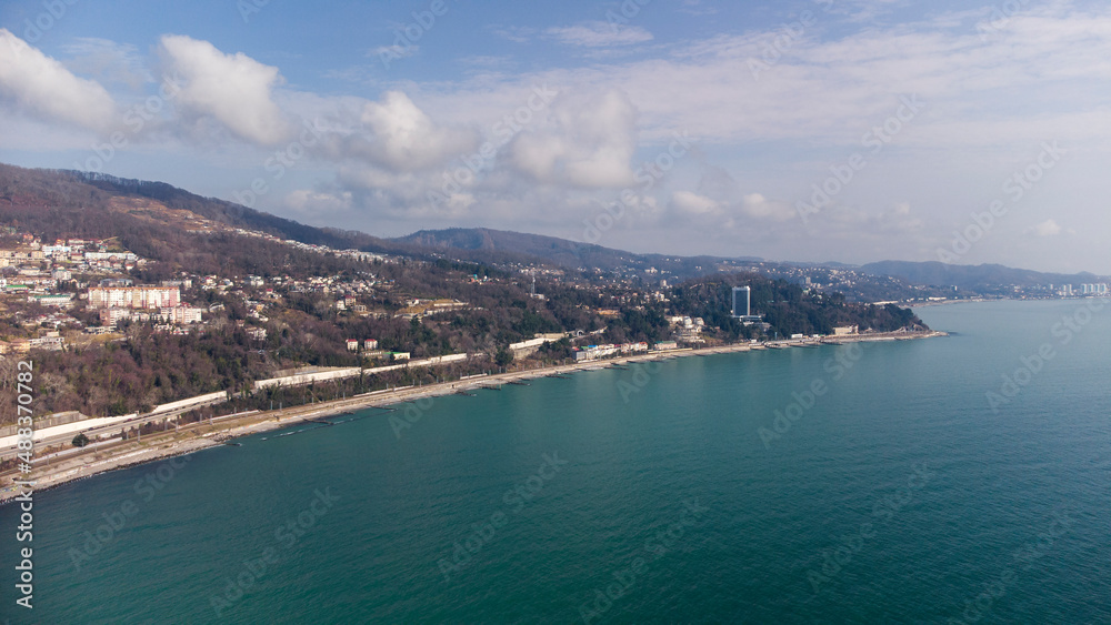 Aerial view of the southern city along the seashore. Road and railway along the sea line. Russia, Sochi, Red Storm.