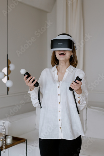 Beautiful woman touching the air during VR experience Joystick in female hand Games at home