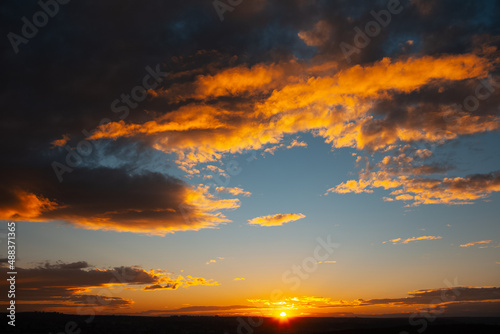 Sunset on horizon. Beautiful natural landscape. Dark cloudy sky.