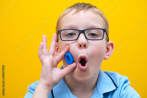 speech therapy, the boy learns to pronounce sounds and words correctly