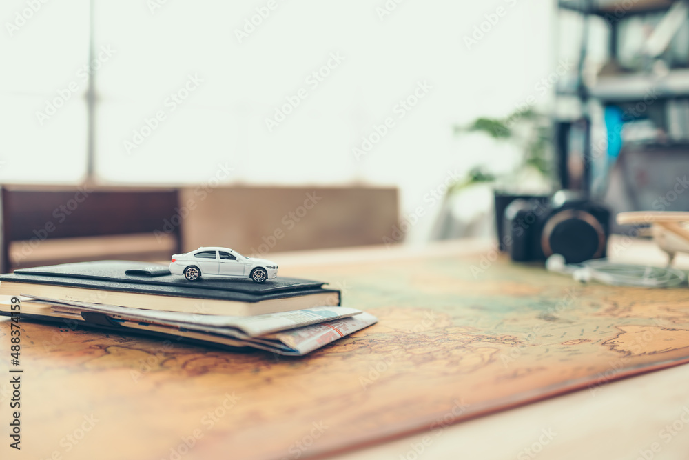 Car on book and Road map insert in book, compass, magnifying glass and passport on world map. Travel , Adventure and Discovery concept. Car on book and Road map insert in book, compass, magnifying glass and passport on world map. Travel , Adventure and Discovery concept.