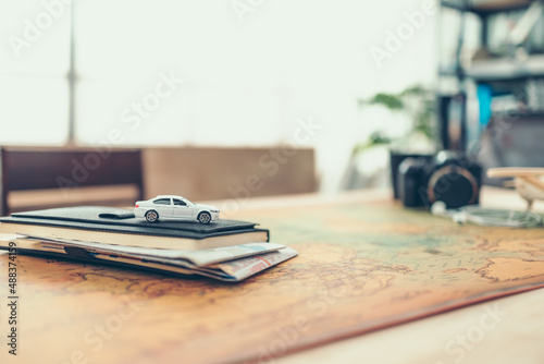 Wallpaper Mural Car on book and Road map insert in book, compass, magnifying glass and passport on world map. Travel , Adventure and Discovery concept. Torontodigital.ca