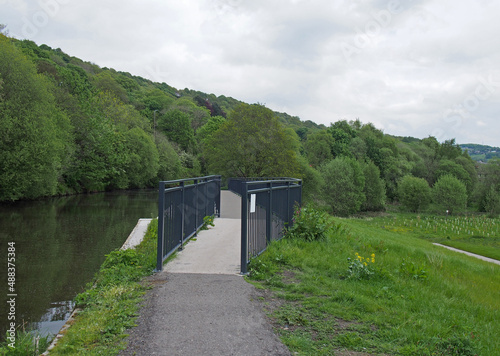 raised pedestrian footbridge over the brearley fields canal spillway next to the river calder in west yorkshire