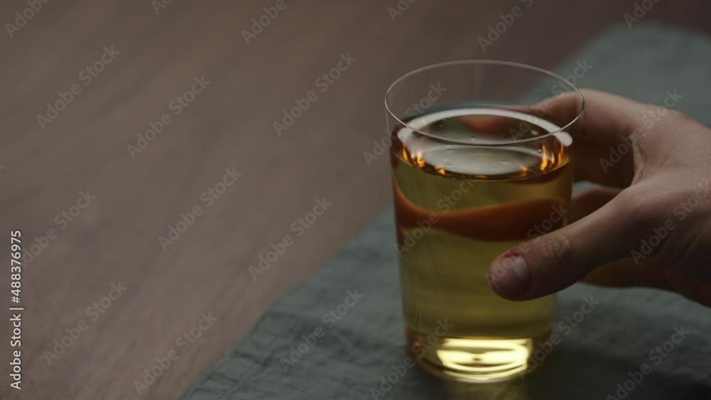 Slow motion man hand take apple cider in tumbler glass with copy space Slow motion man hand take apple cider in tumbler glass with copy space