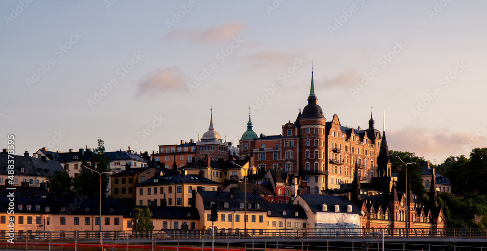 Fototapeta premium Stacked buildings on a hill in Stockholm Sweden during summer sunset