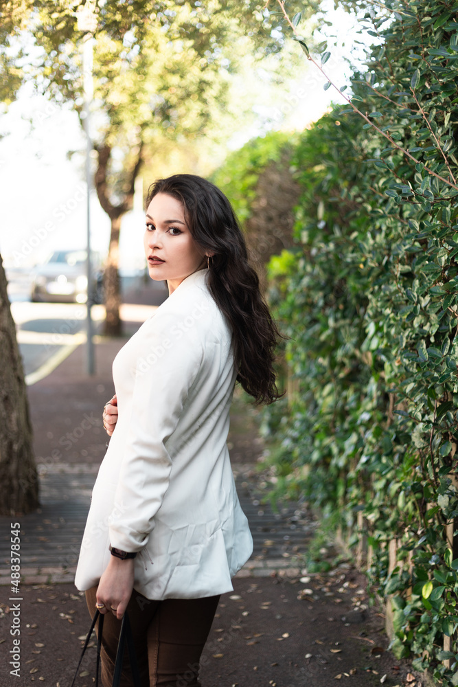 Young caucasian sexy business woman walking on a summer town street. Young caucasian sexy business woman walking on a summer town street.