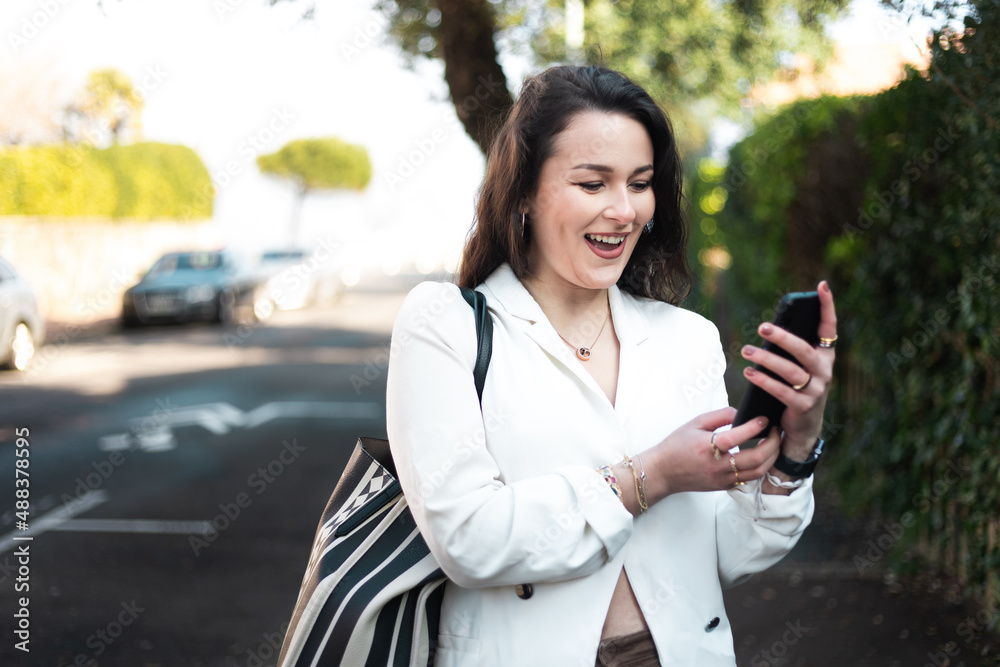 Young caucasian woman walking on the street using a smartphone. Young caucasian woman walking on the street using a smartphone.